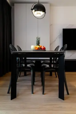 a black dining room table with chairs and a fruit on it at Househost Apartment Retoryka in Kraków
