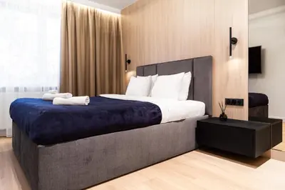 a bedroom with a large bed with a blue blanket at Househost Apartment Retoryka in Kraków