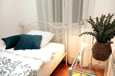 a bedroom with a white bed with a potted plant at Old Town Apt - 5 bedrooms Sołtyka S2 in Kraków