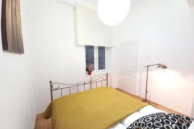 a small bedroom with a bed with a yellow blanket at Old Town Apt - 5 bedrooms Sołtyka S2 in Kraków