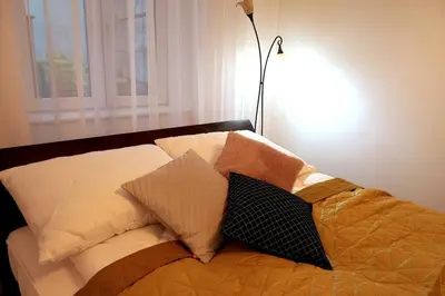 a bedroom with a bed with pillows and a lamp at Old Town Apt - 5 bedrooms Sołtyka S2 in Kraków