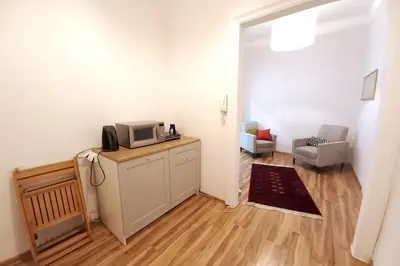 a living room with a tv on a cabinet with a microwave at Old Town Apt - 5 bedrooms Sołtyka S2 in Kraków