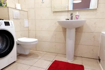 a bathroom with a sink and a washing machine at Old Town Apt - 5 bedrooms Sołtyka S2 in Kraków