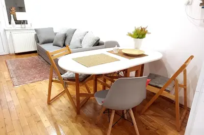 a table and chairs in a living room with a couch at Old Town Apt - 5 bedrooms Sołtyka S2 in Kraków