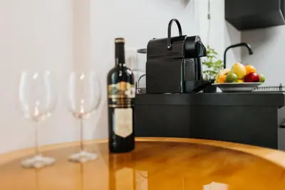 a bottle of wine sitting on a table with two wine glasses at Golden Merchant Main Square in Kraków