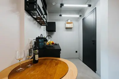 a kitchen with a wooden table and two wine glasses at Golden Merchant Main Square in Kraków