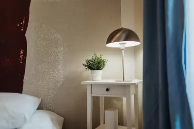 a table with a lamp and a potted plant on it at Golden Merchant Main Square in Kraków