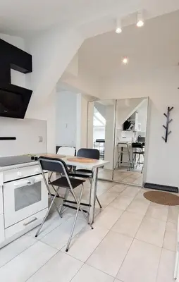 a kitchen and dining room with a table and chairs at LION apartments - Elegance in Kraków