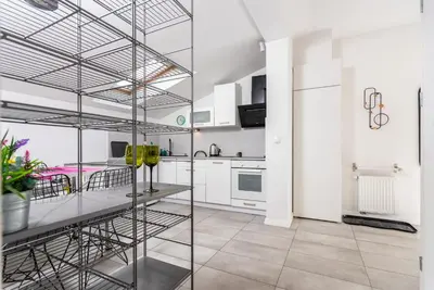 a kitchen with white cabinets and a glass wall at LION apartments - Elegance in Kraków