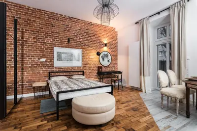 a bedroom with a brick wall and a bed at LION apartments - Elegance in Kraków