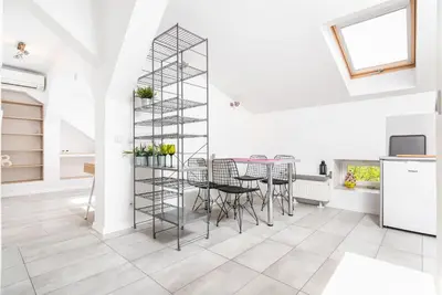 a kitchen and dining room with a metal shelving unit at LION apartments - Elegance in Kraków