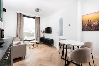 a kitchen and living room with a table and chairs at City of the Kings - Riverside K22 m44 in Kraków