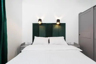a bedroom with a white bed and a green headboard at City of the Kings - Riverside K22 m44 in Kraków