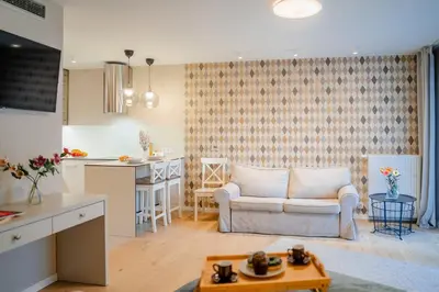 a living room with a couch and a kitchen at Comfy Apartment Old Town - by Hosty in Kraków