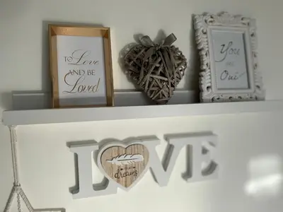 a shelf with two pictures and a heart on it at Zaczarowane Wzgórze - Domek w Beskidach in Czaniec
