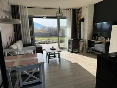 a living room with a couch and a table at Zaczarowane Wzgórze - Domek w Beskidach in Czaniec