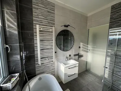 a bathroom with a tub and a sink and a mirror at Zaczarowane Wzgórze - Domek w Beskidach in Czaniec