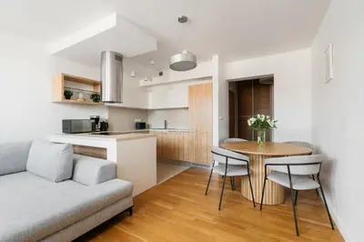 a living room and kitchen with a couch and a table at Native Apartments Kraszewskiego 26 in Kraków