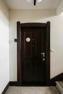 a black door in a room with white walls at Native Apartments Kraszewskiego 26 in Kraków