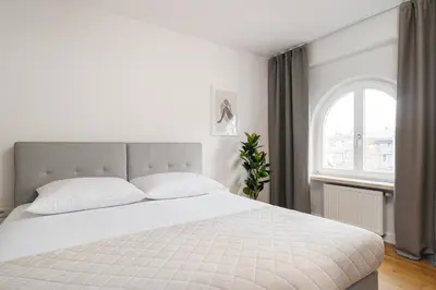 a bedroom with a white bed and a window at Native Apartments Kraszewskiego 26 in Kraków