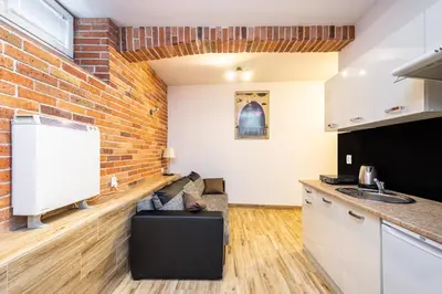 a kitchen with a brick wall and a counter at RentPlanet - Studio Mazowiecka in Kraków