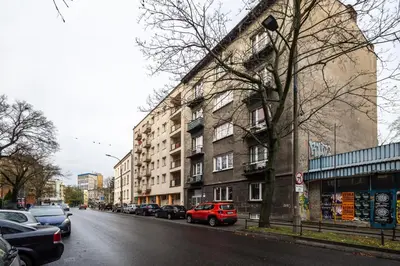 a red car parked on a street next to a building at RentPlanet - Studio Mazowiecka in Kraków