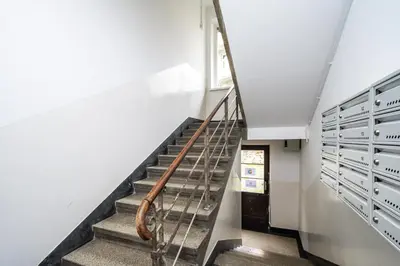 a staircase with a metal handrail and lockers at RentPlanet - Studio Mazowiecka in Kraków