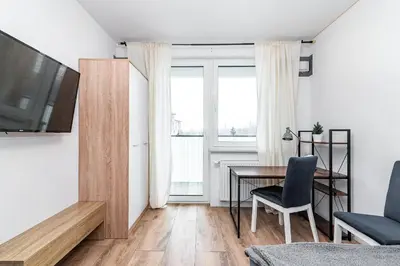 a living room with a desk and a television and a table at Loft Apartment in Kraków