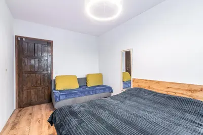 a bedroom with a bed and a couch in it at Loft Apartment in Kraków