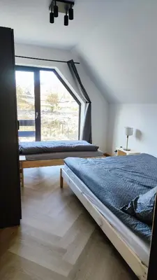 two beds in a room with a large window at Stodoła pod Bacówką Zawoja Sauna Jacuzzi in Skawica