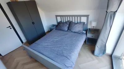 a bedroom with a bed with a blue comforter at Stodoła pod Bacówką Zawoja Sauna Jacuzzi in Skawica