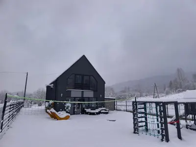 a black house in the snow with at Stodoła pod Bacówką Zawoja Sauna Jacuzzi in Skawica