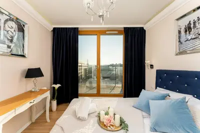a bedroom with a bed and a large window at Malila Premium Apartments Cracow Masarska 11 in Kraków