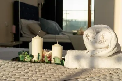 a towel on a table with candles in a room at Malila Premium Apartments Cracow Masarska 11 in Kraków
