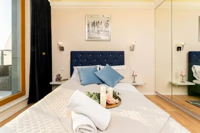 a bedroom with a large white bed with blue pillows at Malila Premium Apartments Cracow Masarska 11 in Kraków