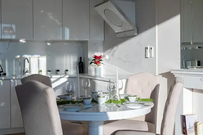 a kitchen with a white table and chairs and a table and chairsktop at Malila Premium Apartments Cracow Masarska 11 in Kraków