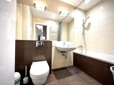 a bedroom with a white bed with a large window at Apartament Reja 11 in Kraków