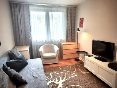 a living room with a blue couch and a chair at Apartament Reja 11 in Kraków