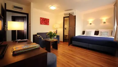 a hotel room with a bed and a couch at Armon Residence in Kraków
