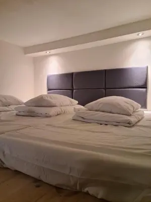 a large bed with two pillows on top of it at Amber Hostel in Kraków