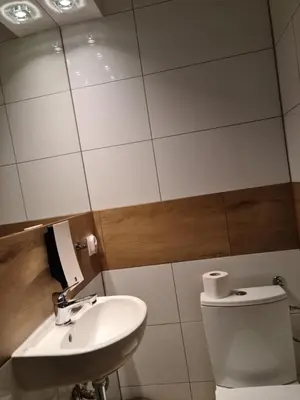 a bathroom with a sink and a toilet and a mirror at Amber Hostel in Kraków