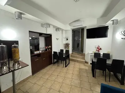 a living room with a table and chairs and a television at Amber Hostel in Kraków