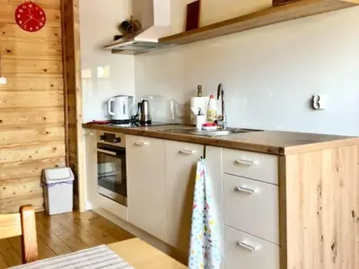 a kitchen with white cabinets and a counter top at Makowy Domek in Maków Podhalański