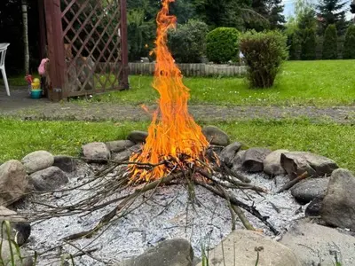 a fire pit with a pile of sticks and rocks at Makowy Domek in Maków Podhalański