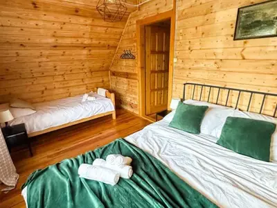 a bedroom with two beds in a log cabin at Makowy Domek in Maków Podhalański