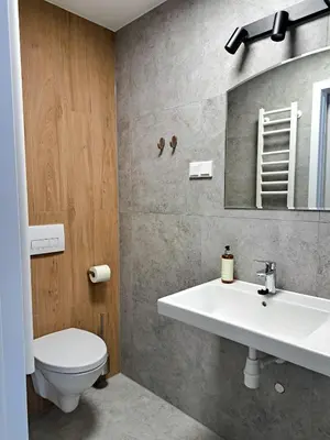 a bathroom with a sink and a toilet at Sympo Apartments in Kraków