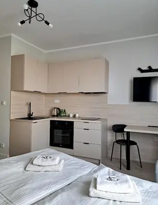 a kitchen with a bed with two towels on it at Sympo Apartments in Kraków