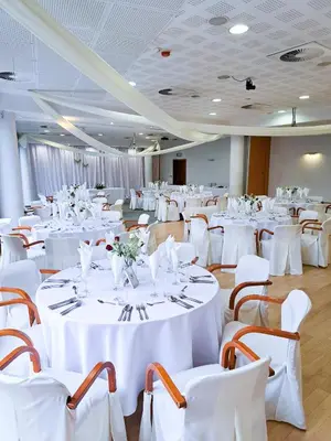 a banquet hall with white tables and chairs at Sympo Apartments in Kraków