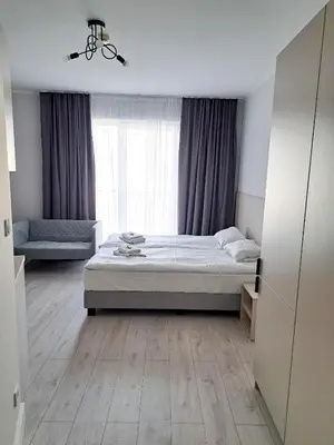 a bedroom with a bed and a window at Sympo Apartments in Kraków