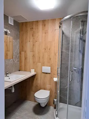 a bathroom with a toilet and a sink and a shower at Sympo Apartments in Kraków